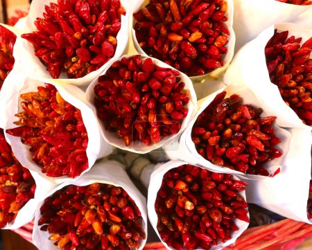 Bunches of red spicy dried chili peppers on sale at the fruit and vegetable market
