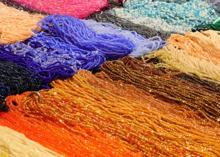 colliers colorés en verre coloré et enfilés sur du fil de nylon dans la boutique vendant des accessoires de mode