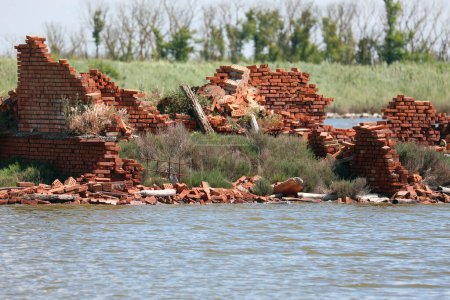 Téléchargez les photos : Ruines d'une ancienne maison détruite en briques rouges après le déluge et l'eau stagnante - en image libre de droit