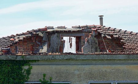 Das völlig zerstörte Dach des beschädigten Hauses weist ein Loch auf, das von innen nach außen reicht