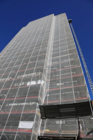 huge scaffolding of the gigantic skyscraper during maintenance to install the thermal insulation for energy saving without people
