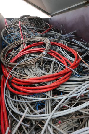 Foto de Cable eléctrico rojo para muy alta tensión y también muchos cables eléctricos utilizados en el vertedero de material reciclable para evitar contaminar el medio ambiente - Imagen libre de derechos