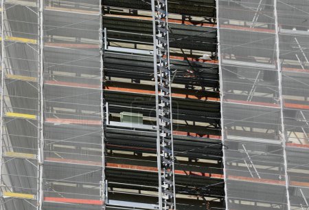 Detalle de rascacielos con andamios de construcción para la instalación de paneles aislantes para ahorrar dinero