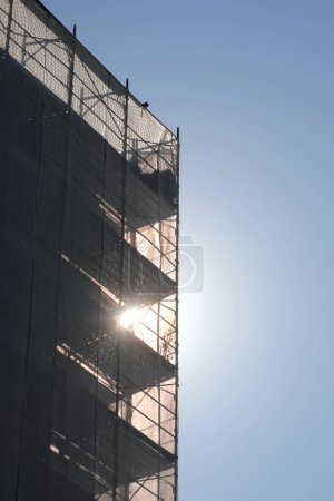 andamios del gran edificio en mantenimiento contra la luz sin trabajadores visibles