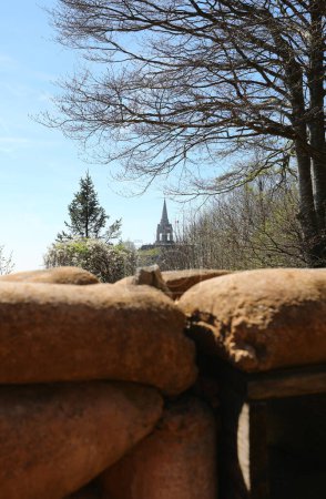 Téléchargez les photos : Tranchée étroite creusée dans le sol avec des sacs de sable pour protéger les soldats et l'ossuaire de Monte Cimone visible en Italie - en image libre de droit