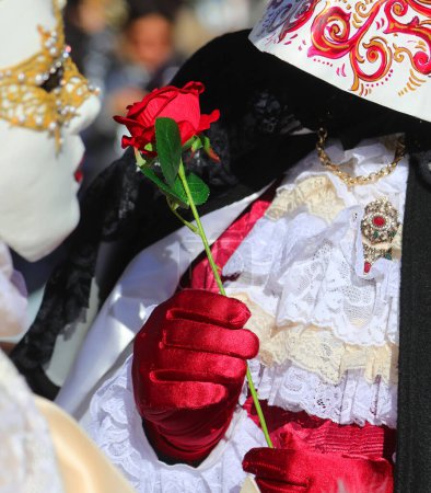 Foto de Personajes enmascarados en el carnaval y el regalo de una rosa roja con el guante en Venecia - Imagen libre de derechos