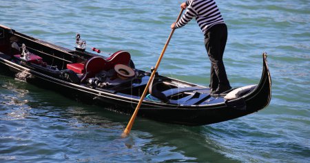 Gondolier with oar on the Gondola Boat while rowind in the Grand Canal in Venice ITALY