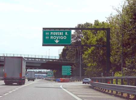 Cruce de la autopista norte de Italia con señales para las ciudades de Rovigo y Piovene y algunos camiones