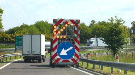 Foto de Camión de mantenimiento de la carretera con un letrero superior con una flecha grande para señalar el estrechamiento del carril - Imagen libre de derechos