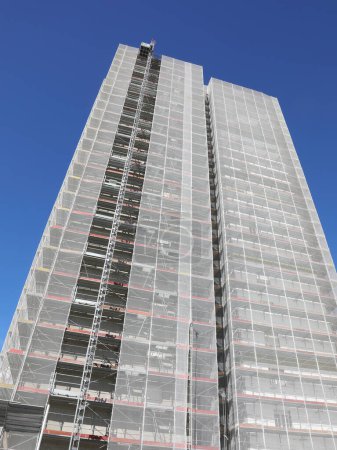 sehr hoher Wolkenkratzer mit einem Gerüst für die Installation von Wärmedämmplatten zum Schutz der Umwelt