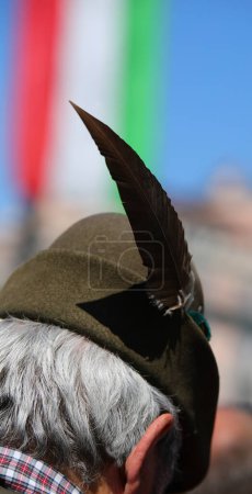Homme italien âgé portant un chapeau Alpini avec une plume noire