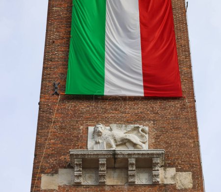 Statue of Winged Lion of Saint Mark and the very big italian flag