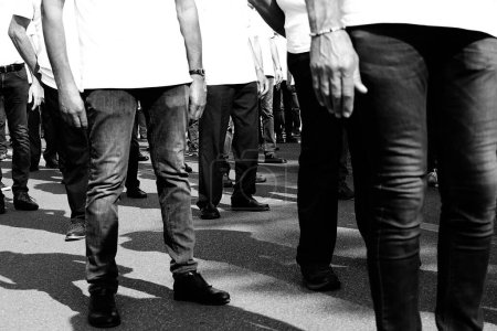 Crowd of men walking down the street in jeans during a workers strike