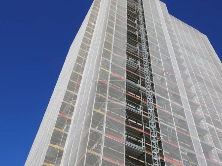 Échafaudage d'un gratte-ciel lors de travaux de maintenance extraordinaires pour l'installation de panneaux en polyuréthane pour l'isolation thermique et les économies d'énergie