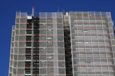 detail of the skyscraper with the scaffolding all around during the installation of the panels for thermo-acoustic insulation