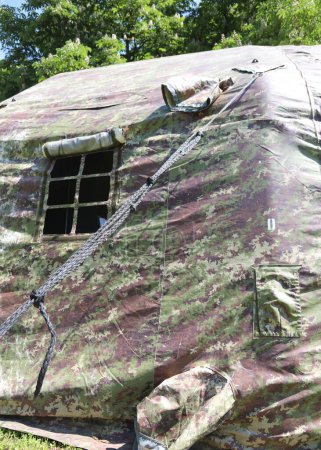 Foto de Tiendas militares con tela de camuflaje verde en un campo de entrenamiento cerca de la zona de guerra - Imagen libre de derechos
