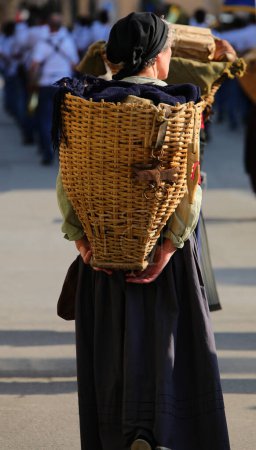 recreación histórica con la mujer que lleva una cesta de mimbre en el papel de Portatrici Carniche un grupo de patriotas italianos de la guerra