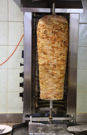grande brochette Kebab avec viande qui tourne sur elle-même avec un effet de mouvement dans la zone à manger