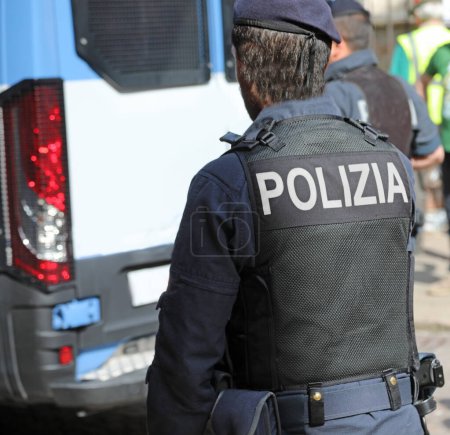 Photo for Vicenza, VI, Italy - May 10, 2024: Italian policeman in uniform with large POLIZIA text meaning POLICE in Italian and riot control van - Royalty Free Image
