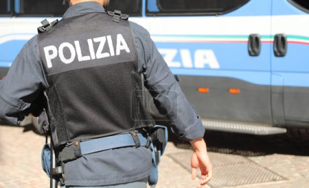 Photo for Vicenza, VI, Italy - May 10, 2024: Italian policeman in uniform with large POLIZIA text meaning POLICE in Italian and riot control van - Royalty Free Image