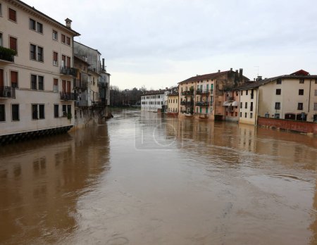 Río inundado durante una inundación y las casas de la población bañadas por el agua en la ciudad