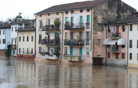 Flooded river during a flood and the houses of the population lapped by the water in the city