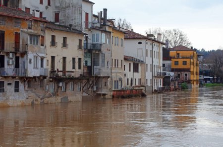 Flooded river during a city flood and the houses of the population lapped by the muddy water