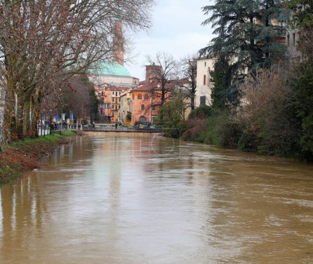 Fluss in Überschwemmung mit schlammigem Wasser, das im historischen Zentrum der Stadt VICENZA in Norditalien über die Ufer tritt
