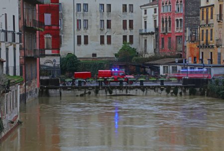Firefighters truck and the flooded river during the flood in the city of Vicenza in Northern Italy