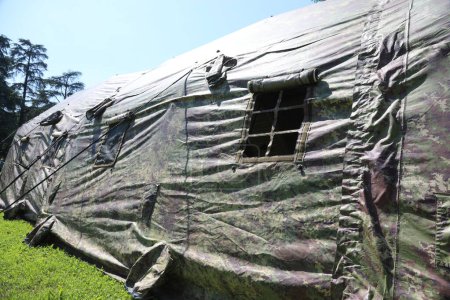 Tentes militaires avec tissu de camouflage dans un camp d'entraînement près de la zone de guerre