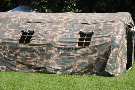 Tentes militaires en tissu de camouflage vert dans un camp d'entraînement près de la zone de guerre
