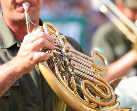 Photo for Hand of Musician playing a french horn during a band parade - Royalty Free Image