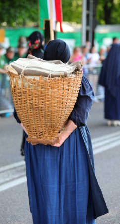 Photo for Carnic Woman Carrying Supplies During World War I Reenactment with wooden  backpack called GERLA in italian language - Royalty Free Image
