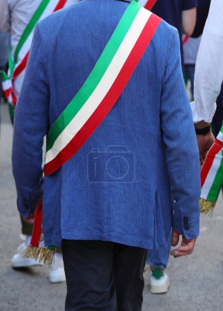 maire marche dans les rues avec la ceinture tricolore italienne pendant le défilé de la ville