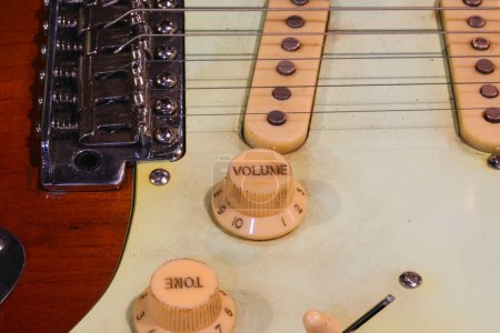 Close-up View of Electric Guitar with metal Bridge Pickups and Control knobs volume and tone