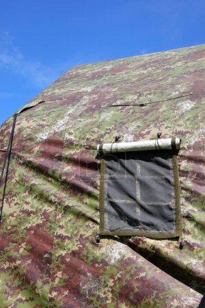 Military tent with camouflage fabric set up in a training camp for army soldiers