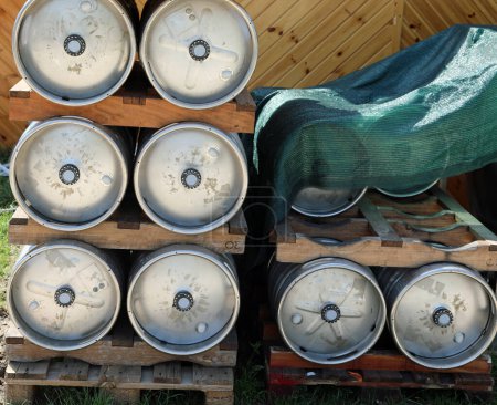 Aluminum beer kegs stacked outside a brewery on pallets