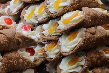 Sicilian cannoli filled with ricotta cheese and with cherry and orange for sale in Sicily Italy