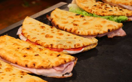 de nombreux pains plats remplis de viandes et légumes salés appelés SPIANATA BOLOGNESE en italien cuit sur une plaque chauffante plat typique de la cuisine ITALIE CENTRALE