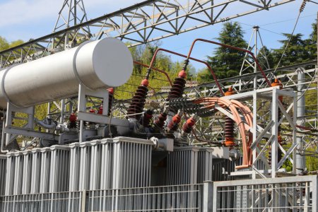 Hochspannungstransformator in einem Kraftwerk mit Kabeln und großem Ölkühltank