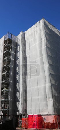 Construcción y andamiaje del condominio durante la instalación de paneles de aislamiento térmico
