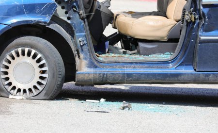 Auto komplett zerstört mit Scheiben am Boden und Reifenplatzer