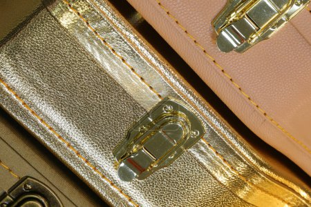 Detail of the clasp on a gold hard case for protecting and transporting musical instruments like guitars and basses
