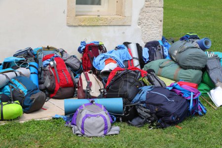 pile colorée de sacs à dos et de sacs de couchage appartenant à de jeunes randonneurs aventureux lors d'un tour du monde