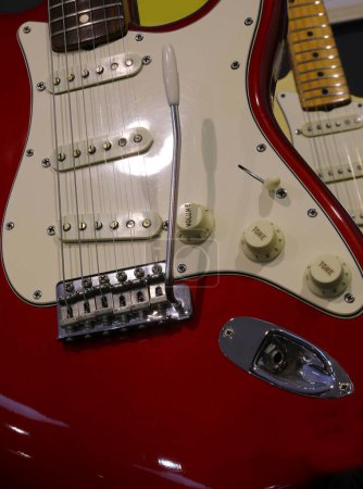 red six-string electric guitar with pickups volume and tone knobs and a tremolo bar