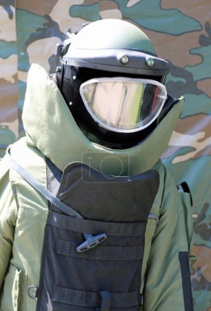 Soldier of the bomb squad with the helmet and visor and bulletproof vest during the inspection of the unexploded order