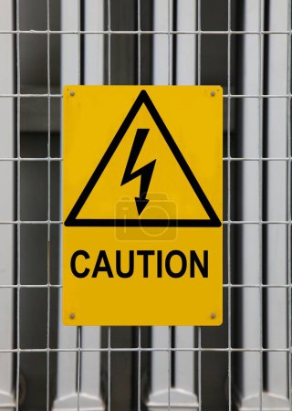 Yellow triangular hazard warning sign with lightning bolt on recycling power plant