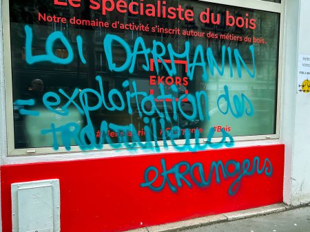 Photo for Paris, France, Street Graffitti Slogan, on Shop Front, Against French Government anti-immigration Politics, 2023 - Royalty Free Image