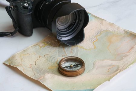 Téléchargez les photos : Boussole vintage sur une carte faite à la main avec une caméra pour planifier une aventure - en image libre de droit