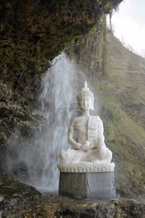 Téléchargez les photos : Bouddha paisible avec un fond de cascade créant sérénité et paix - en image libre de droit